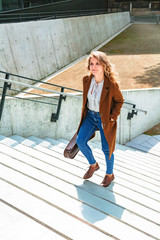 Girl carries violin in hands and climbs stairs