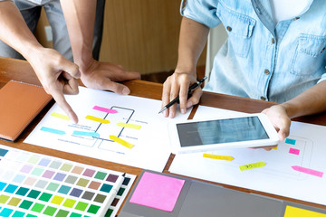 Group of young designer working in the office to design a new product, use color chart and computer laptop for new smartphone design concept