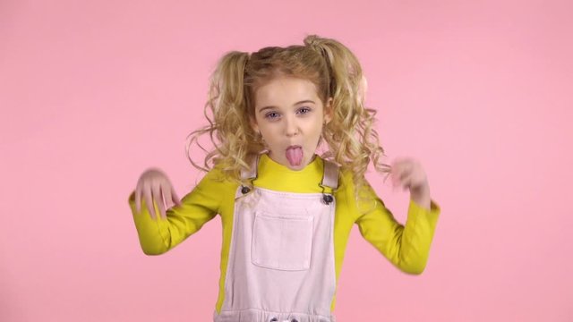 Cute naughty girl is showing her tongue and making faces. Slow motion