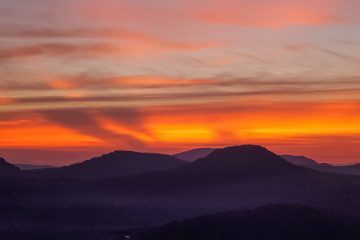Mountain view morning of Peak mountain above Mekong river around with soft mist and red sun light in the sky background, sunrise at Cha Na Dai Cliff, Pha Taem National Park, Ubon Ratchathani, Thailand