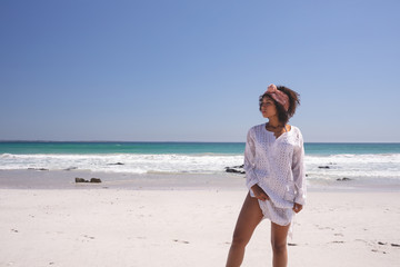 Beautiful woman looking away while standing on the beach