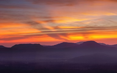 Mountain view morning of Peak mountain above Mekong river around with soft mist and red sun light in the sky background, sunrise at Cha Na Dai Cliff, Pha Taem National Park, Ubon Ratchathani, Thailand