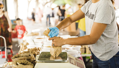 Woman seller packing food for her customer in market