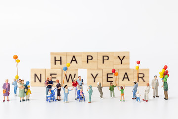 Miniature people Miniature people : Happy family standing on wooden block  Happy new year concept