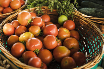 Fototapeta na wymiar Organic red tomato wicker basket at grocery store market