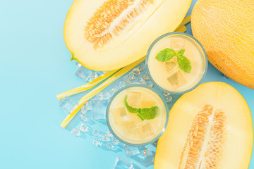 sweet and cold juice from melon in glasses against the background of melon sliced