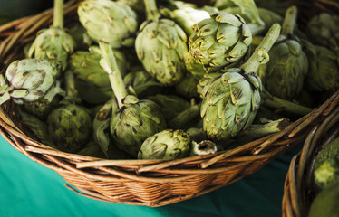 Fresh artichokes in wicker at farmers market