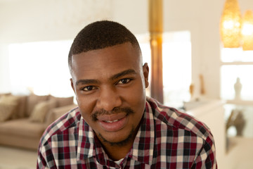 Happy man looking at camera in a comfortable home