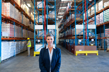 Female manager looking at camera in warehouse