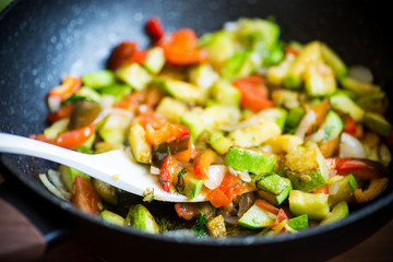 fried zucchini with red pepper, onions, tomatoes and other vegetables