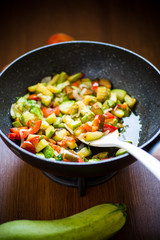 fried zucchini with red pepper, onions, tomatoes and other vegetables