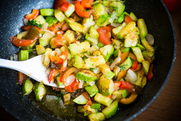 fried zucchini with red pepper, onions, tomatoes and other vegetables