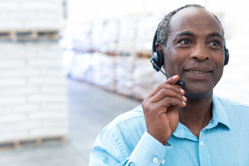 Male supervisor talking on headset in warehouse