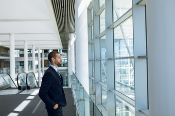 Businessman looking out of window in office lobby