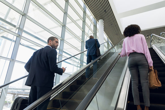 Business People Travelling Up An Escalator