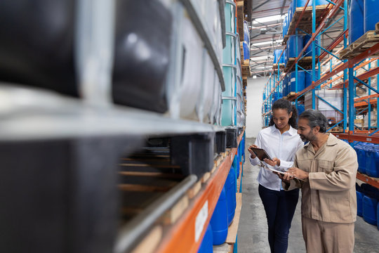 Female Manger And Male Staff Discussing Over Digital Tablet While Checking Stocks