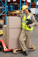 Female staff smiling while standing in warehouse
