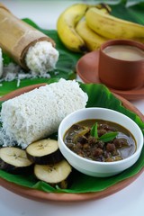 Kerala breakfast rice Puttu /Pittu made in bamboo mould served with Kadala curry banana papad and tea on banana leaf