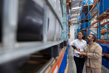 Female manger and male staff interacting with each other while checking stocks