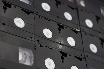 Set of old audio VHS tape on the wall background, large collection of analog black magnetic record technology