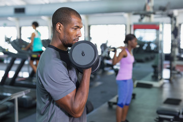 Man exercising with dumbbells in fitness center