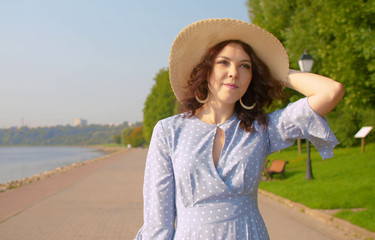 Young woman walking on the embankment along the river