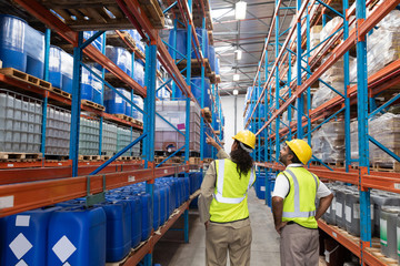 Female worker showing something to male worker in warehouse