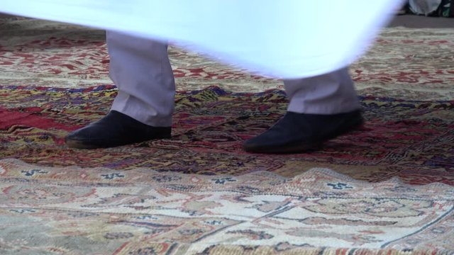 Fethiye, Turkey - 5th of July 2019: 4K Feet movements of a whirling dervish dancing on carpet
