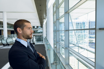 Businessman looking out of window in office lobby