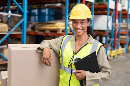 Female staff smiling while standing in warehouse