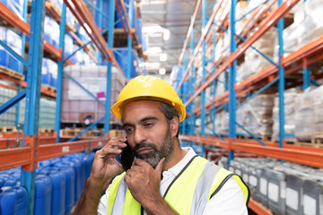 Male worker talking on mobile phone in warehouse