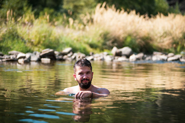 Man cooling down in a river on a summer day