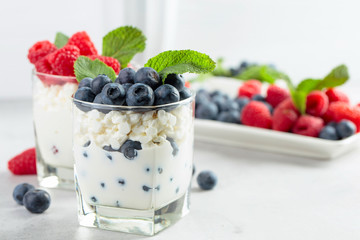 Cottage cheese with cream, raspberry and blueberry garnished with fresh mint.