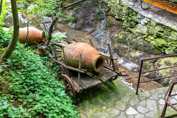 Clay jugs lie on an old wooden cart