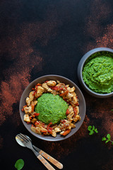 Mashed potatoes with green peas and corn served with chicken and vegetable stew. African cuisine, Kenyan cuisine, a traditional dish called mukimo or irio. Top view, copyspace, vertical