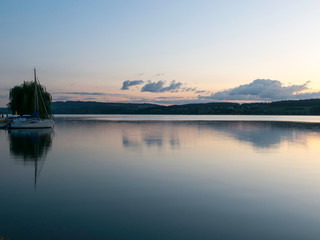 view of the lake at dawn early in the morning, silhouettes of hills and clouds