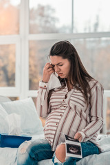 Negative delighted pregnant woman touching her forehead