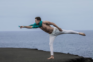 Obraz premium Man stretching out arm and leg on coast