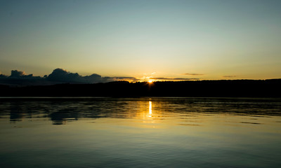 Fototapeta na wymiar early morning on the lake, dusk, sun rising behind the hill