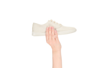 White leather shoes in woman hand isolated on white.