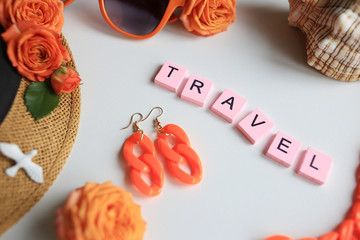 The word travel, sunglasses, shell, hat, roses, on a white background