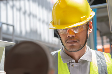 Asian engineer wearing glasses working in the boiler room,maintenance checking technical data of heating system equipment,Thailand people