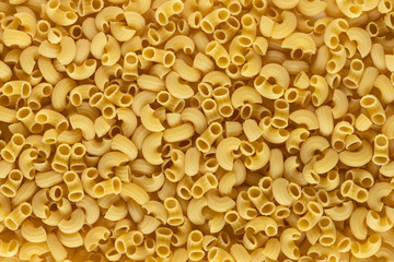 A lot of elbow macaroni shape of italian pasta as background on banner