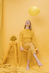 Woman and balloon in a yellow scene