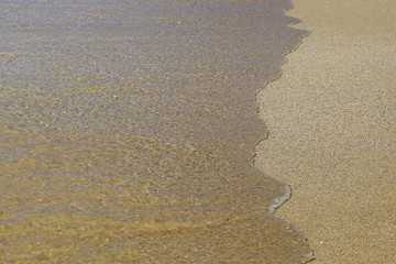 Wave on sandy beach background