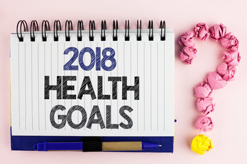 Handwriting text 2018 Health Golas. Concept meaning new year plan Workout healthy food Resolution goals written Notebook Book the plain background Pen next to it Ask for.