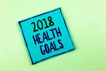 Conceptual hand writing showing 2018 Health Golas. Business photo showcasing new year plan Workout healthy food Resolution goals written Sticky Note Paper the plain background.