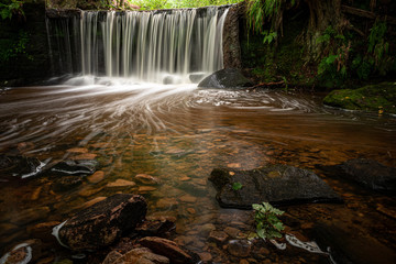 Knypersley Reservoir waterfall in Staffordshire using a long exposure to capture movement in the water.