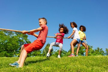 Children pull rope - competitive fun game in park