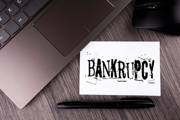 Writing note showing Bankrupcy. Business photo showcasing Company under financial crisis goes bankrupt with declining sales written Sticky Note Paper the wooden background Laptop Mouse Pen